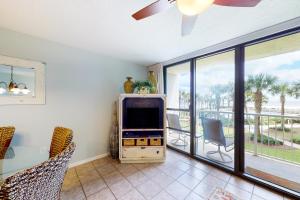 a living room with a tv and a balcony at Seaside Beach & Racquet Club 5215 in Orange Beach