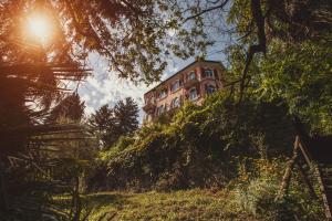 un edificio junto a una colina con árboles en Hotel Monte Verità en Ascona