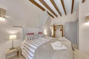 - une chambre avec un grand lit et des serviettes dans l'établissement charmantes und modernes Stadthaus Casa Corazon, à Santanyí