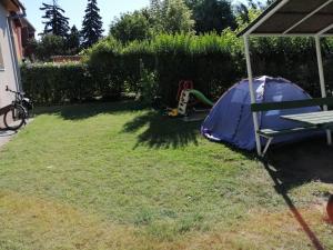 a yard with a tent and a playground at Rigó Vendégház in Siófok