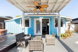 a patio with a ceiling fan on a blue house at Peaceful Lydia Hide-O-Way - Unwind Near Beach, Breakfast, Spa & Go-Karts! in Panama City Beach