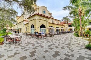 un patio con mesas y sillas frente a un edificio en Northwood Charmer, en West Palm Beach