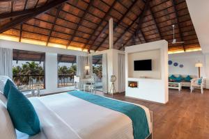 Un dormitorio con una cama y un televisor en una habitación. en Estuary Sarovar Premiere Poovar Island, en Pūvār