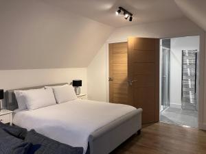 a bedroom with a white bed and a closet at Berryfield Holiday Apartment in Inverness