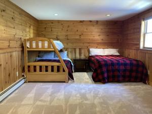 two beds in a room with wooden walls at Chester Charmer in Chester