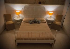 1 Schlafzimmer mit 2 Lampen und 1 Bett mit 2 Stühlen in der Unterkunft Al Vicoletto in Ginosa