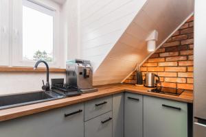a kitchen with a counter with a sink and a window at Willa Green in Kąty Rybackie