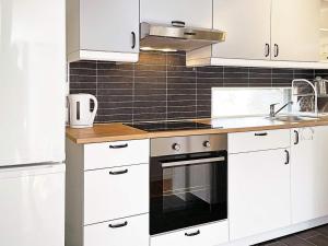 a kitchen with white cabinets and a stove top oven at Holiday home RAA HELSINGBORG in Pålstorp