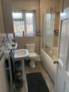 a bathroom with a toilet and a sink and a shower at Stylish, cosy, home with off-road parking 