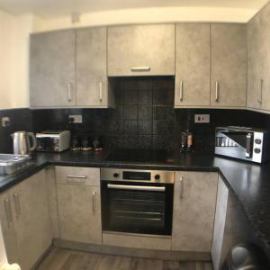 a kitchen with stainless steel cabinets and an oven at Stylish, cosy, home with off-road parking 