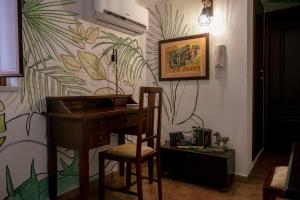escritorio y silla en una habitación con pared en Tetti & Chiese - Authentic Sicilian Rooftop, en Catania