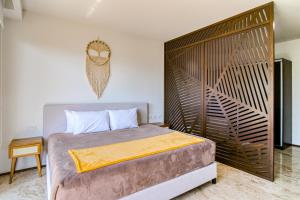 a bedroom with a bed with a large wooden headboard at Menesse Tulum #204A Downtown in Tulum