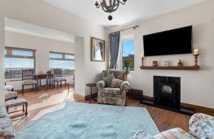 uma sala de estar com lareira e uma televisão de ecrã plano em Edith Villas - Luxury seaside home with beautiful sea views-Pendine em Pendine