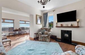 a living room with a fireplace and a flat screen tv at Pendine Sands Edith Villas - a luxury seaside home with beautiful sea views in Pendine