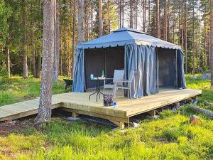 Tienda azul con mesa y sillas en una terraza de madera en Holiday home Bureå en Bureå