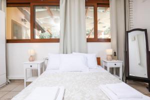 a bedroom with a large bed with two tables and a mirror at ΒeΙΙa Kanoni Corfu in Kanoni