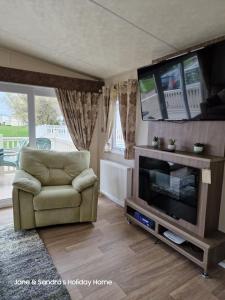 ein Wohnzimmer mit einem Sofa und einem TV in der Unterkunft PRIVATELY OWNED Stunning Caravan Seawick Holiday Park St Osyth in Jaywick Sands
