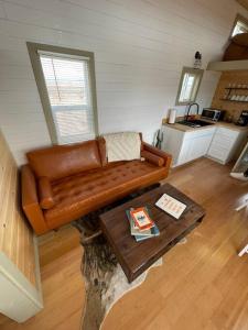 ヴァジェにあるGrand Canyon Hideaway Tiny homeのリビングルーム(革張りのソファ、コーヒーテーブル付)