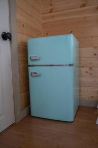 a white refrigerator in a room with a wooden wall at Grand Canyon Hideaway Tiny home in Valle