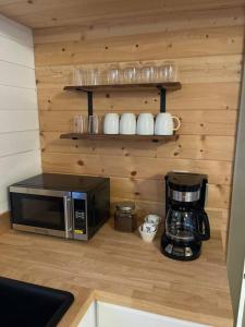 a kitchen counter with a microwave and a coffee maker at Grand Canyon Hideaway Tiny home in Valle