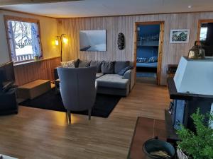 ein Wohnzimmer mit einem Sofa und einem Tisch in der Unterkunft Loghouse apartment in arctic wonderland! in Kvaløya