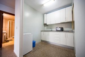 ベニドルムにあるOne bedroom Flat with shared pool in Acuarium IIの白いキャビネットとシンクのあるキッチン +8枚の写真