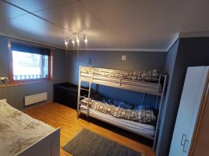 Loghouse apartment in arctic wonderland! في Kvaløya: غرفة نوم بسريرين بطابقين في غرفة