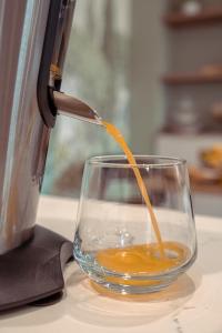 a drink is being being poured into a glass at Les clés d'à côté - maison d'hôtes de charme près de Rouen in Sotteville-lès-Rouen