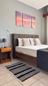 a bedroom with a bed and a table and three windows at Artemis Hotel Apartments in Keramotí