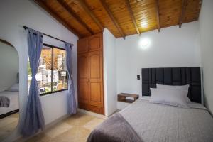 a bedroom with a large bed and a window at Espectacular casa cerca a parques turisticos in Medellín