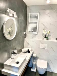 Baño blanco con lavabo y aseo en Góralskie Apartamenty Trimont en Czorsztyn