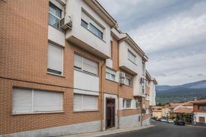 um edifício de tijolos com janelas numa rua em El Refugio de Sabina em Arenas de San Pedro