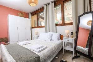 1 dormitorio con cama blanca y espejo en ΒeΙΙa, en Kanoni