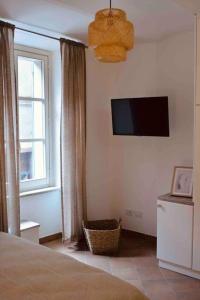 a bedroom with a bed and a television on the wall at Una perla in pieno centro in Perugia