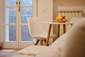a room with a table and white chairs and a window at Una perla in pieno centro in Perugia +18 photos