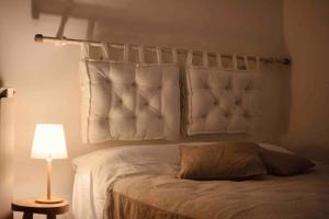 a bedroom with a bed with a white headboard and a lamp at Una perla in pieno centro in Perugia