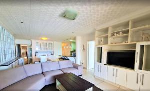 a living room with a couch and a tv at Santorini Unit RR in Margate