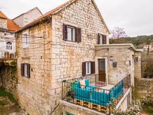 an old stone house with a blue balcony at Kuća za odmor INK in Nerežišće