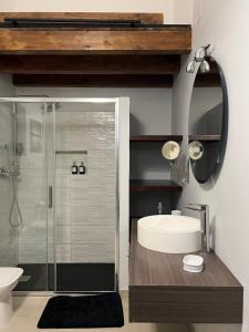 ein Bad mit einer Glasdusche und einem Waschbecken in der Unterkunft GDM central apartment Palermo in Palermo