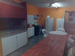 a kitchen with a table and a kitchen with a refrigerator at TU LUGAR in Villa Cura Brochero