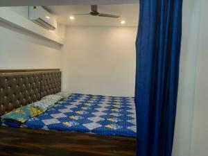 a bed in a room with a blue curtain at CHINTA HARAN REST HOUSE in Deoghar