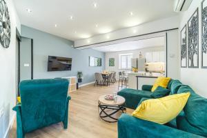 a living room with two green couches and a kitchen at Kuća za odmor INK in Nerežišće