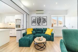 a living room with a green couch and a table at Kuća za odmor INK in Nerežišće