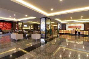 a lobby of a hotel with white chairs and tables at Grand Asia Hotel in Makassar