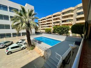basen z palmą przed budynkiem w obiekcie Portus apartment with pool w mieście Santa Pola
