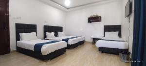 um quarto de hotel com duas camas e uma televisão em Happy Beach For Studio Rooms Apartment em Aqaba