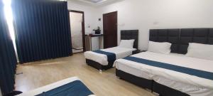 una habitación de hotel con 2 camas en una habitación en Happy Beach For Studio Rooms Apartment, en Áqaba