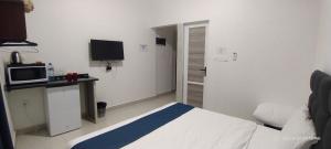 a hotel room with a bed and a microwave at Happy Beach For Studio Rooms Apartment شاطئ السعادة للشقق المفروشة in Aqaba