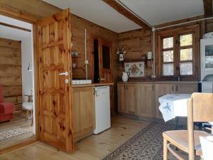 una cucina con pareti in legno e porta in legno di Domek z bali Roztocze a Sieniawa