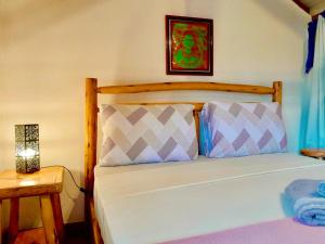 グアルダ・ド・エンバウーにあるRecanto das Bromélias Chalésのベッドルーム1室(木製ヘッドボード付きのベッド1台付)